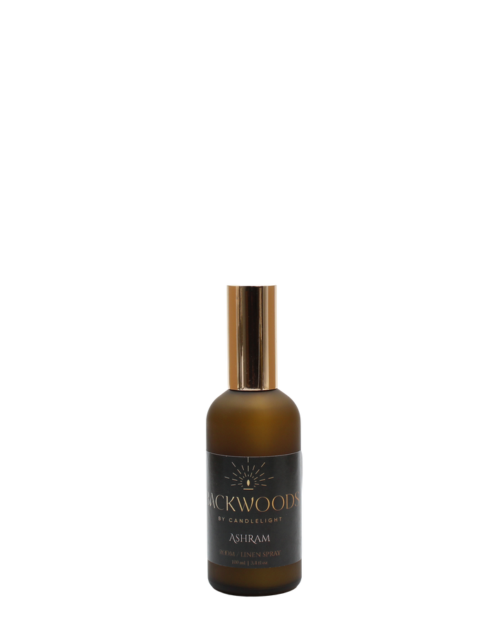 Room & Linen Spray bottle labeled 'Backwoods by Candlelight Ashram' on a white background