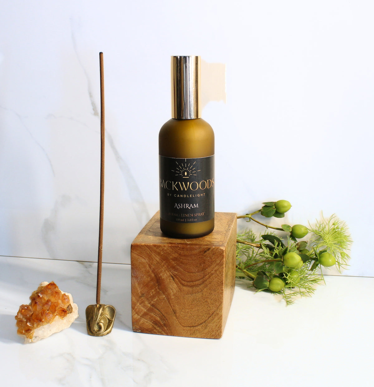 Room & Linen Spray bottle labeled 'Backwoods by Candlelight Ashram' on a white background