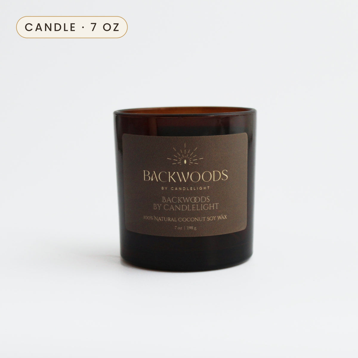 Backwoods By Candlelight 7 oz candle in an amber glass jar with a gold foil label