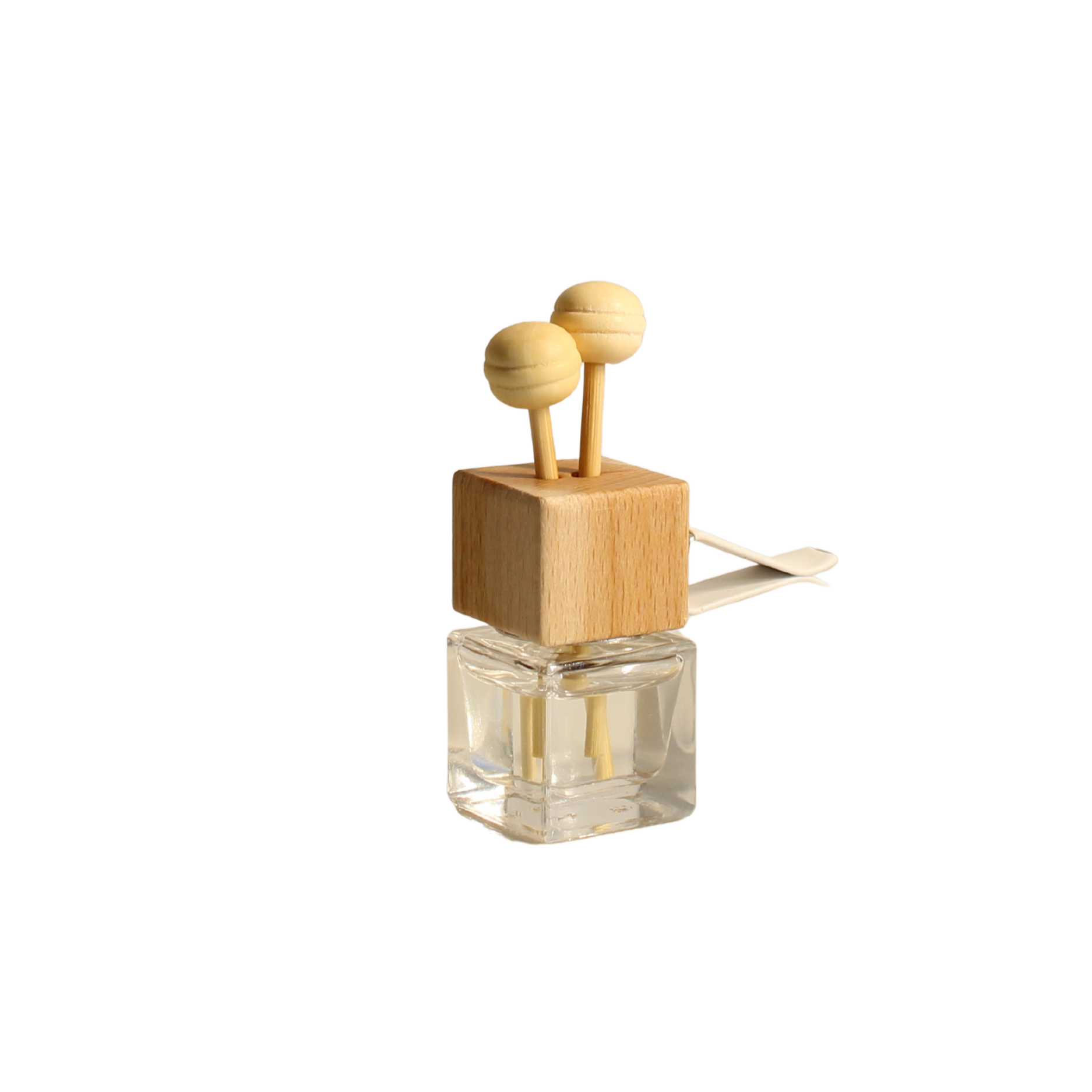 Clear  car  diffuser bottle with wooden top and two spherical objects on a white background