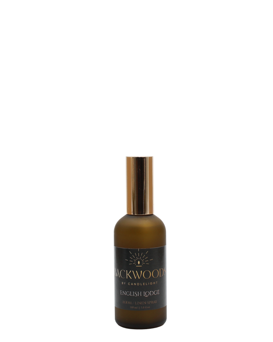 Brown spray bottle with gold cap labeled 'Backwoods by Candlelight English Lodge' on a white background