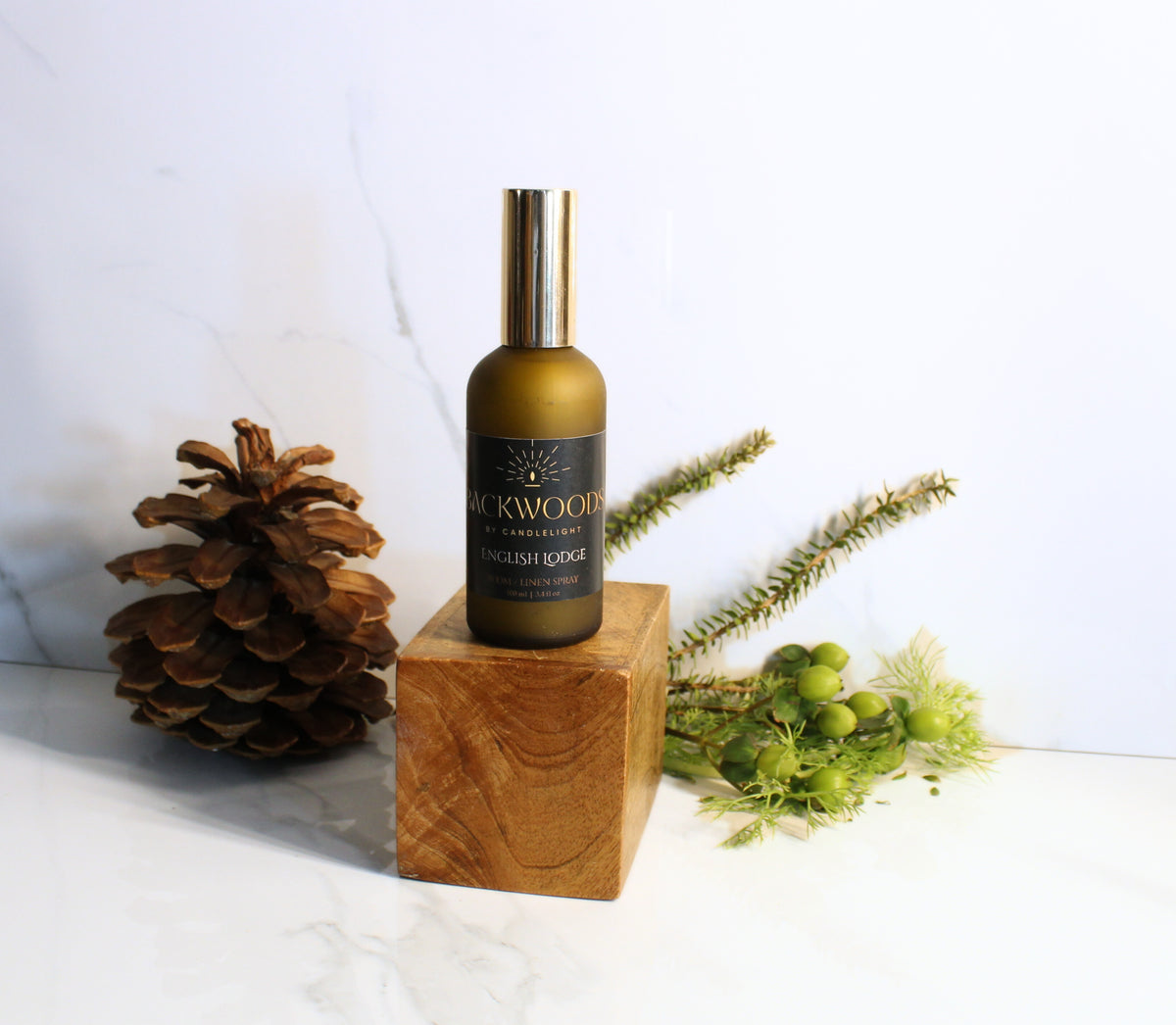 Room spray bottle labeled 'Backwoods by Candlelight' on a white background