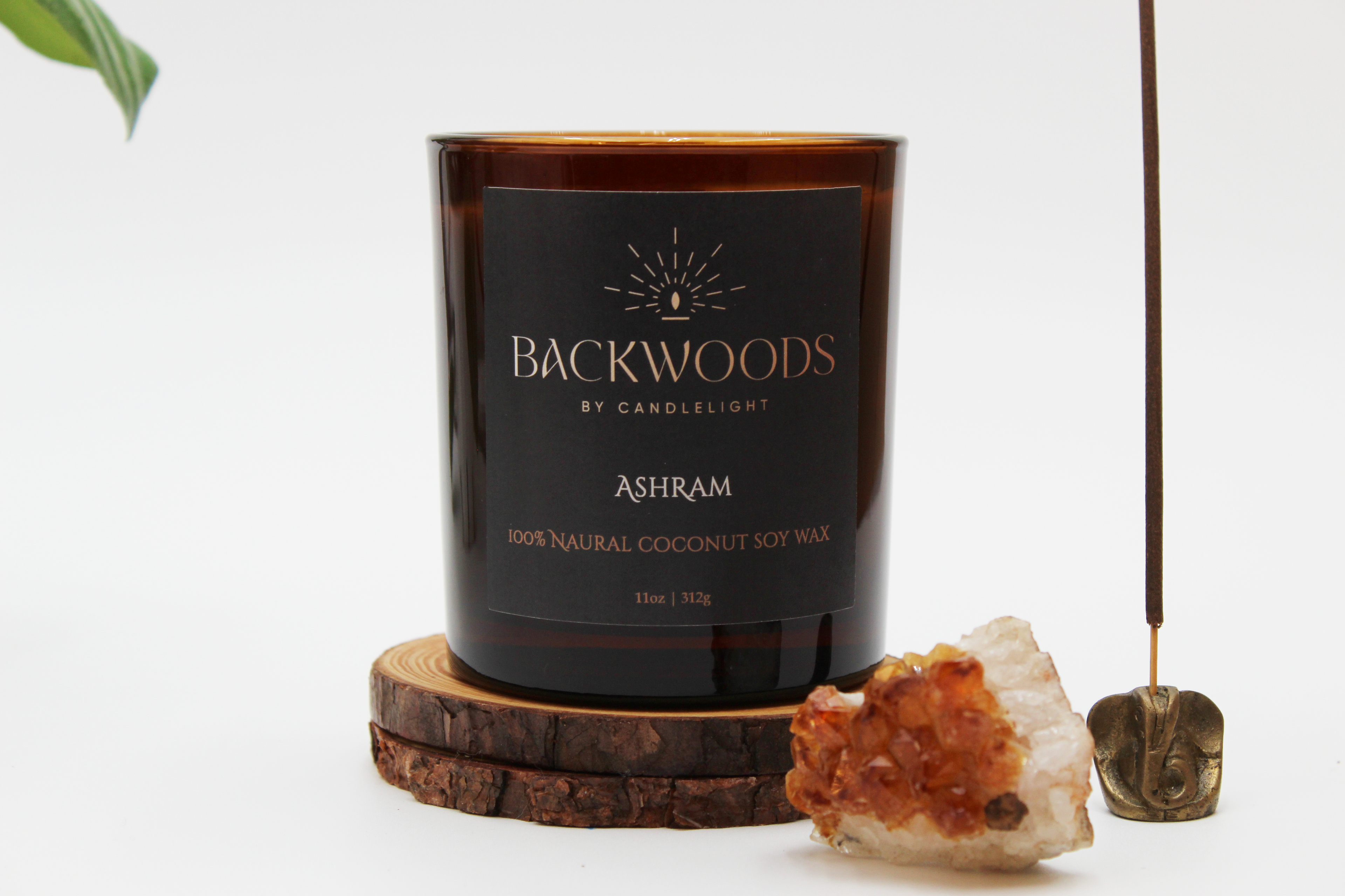Backwoods By Candlelight all natural candle, non-toxic candle. Ashram front label with crystal, leaf, wooden wick and candle coaster.