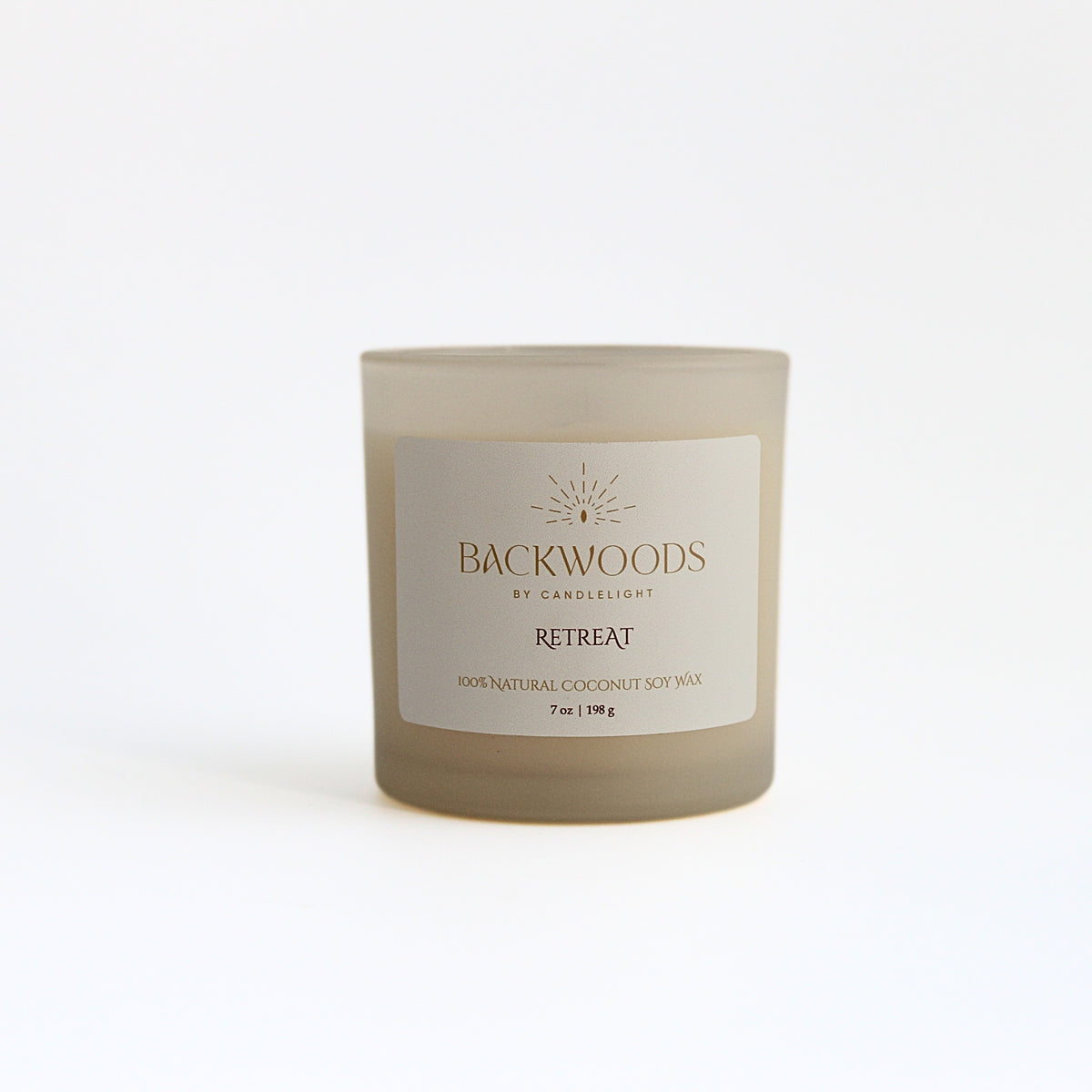 Retreat 7 oz wooden wick candle in a frosted ivory jar with a cream and gold label, on a white background